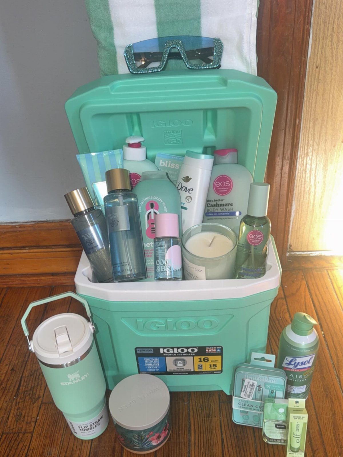 Mint green cooler filled with toiletries and skincare products as a raffle basket.
