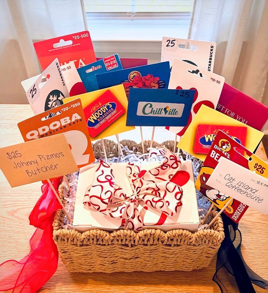 Wicker basket with a gift box and a bouquet of various colorful gift cards.