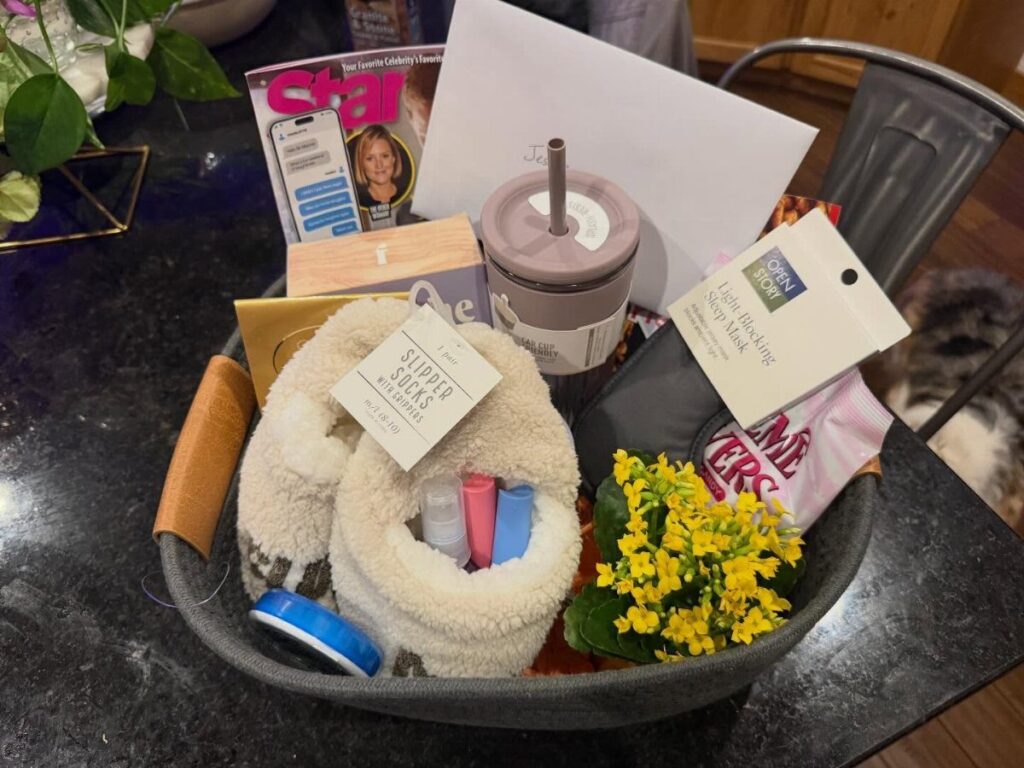 Get well basket containing fluffy socks, a tumbler, magazine, and yellow flowers.