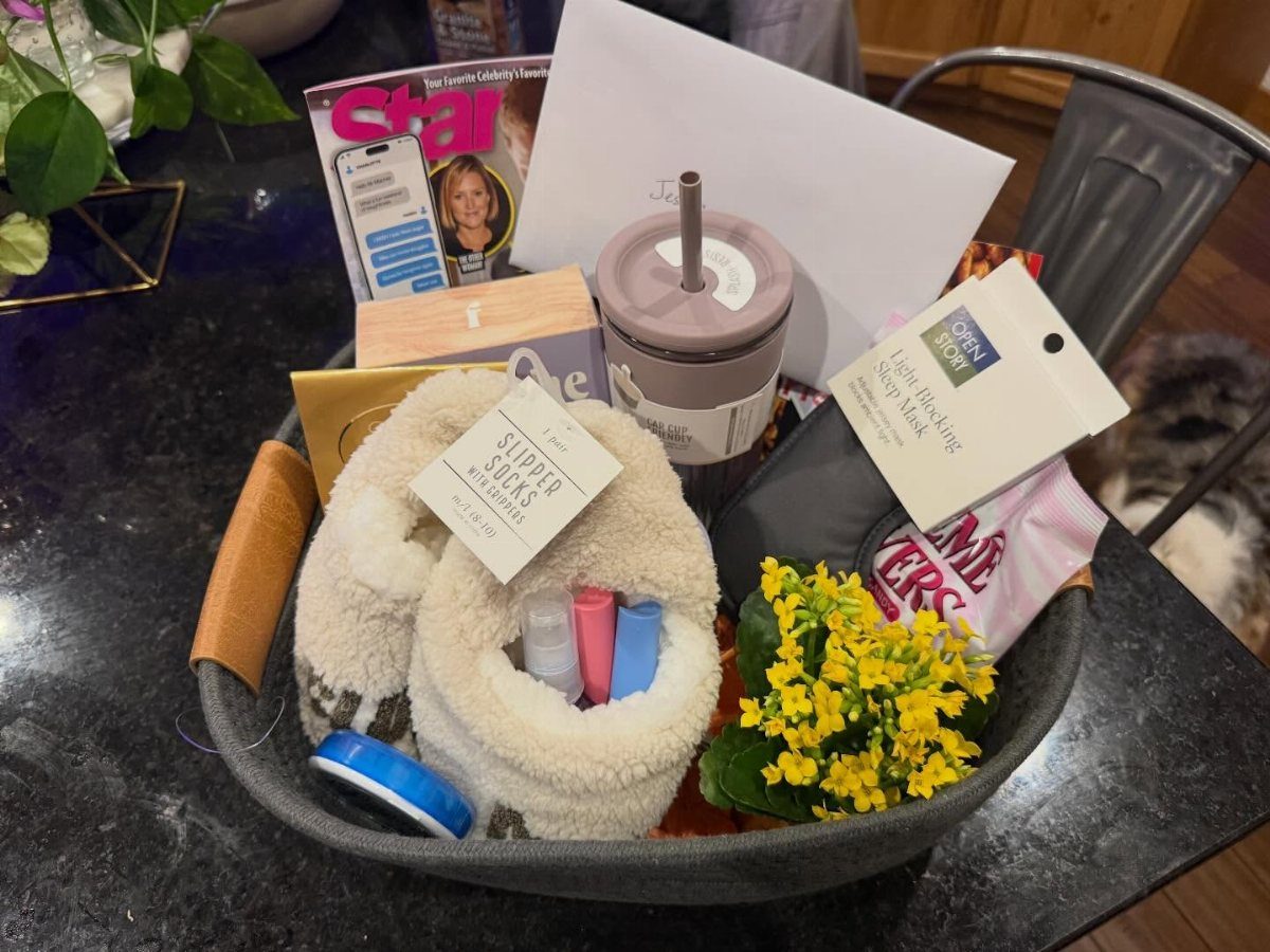 Get well basket containing fluffy socks, a tumbler, magazine, and yellow flowers.