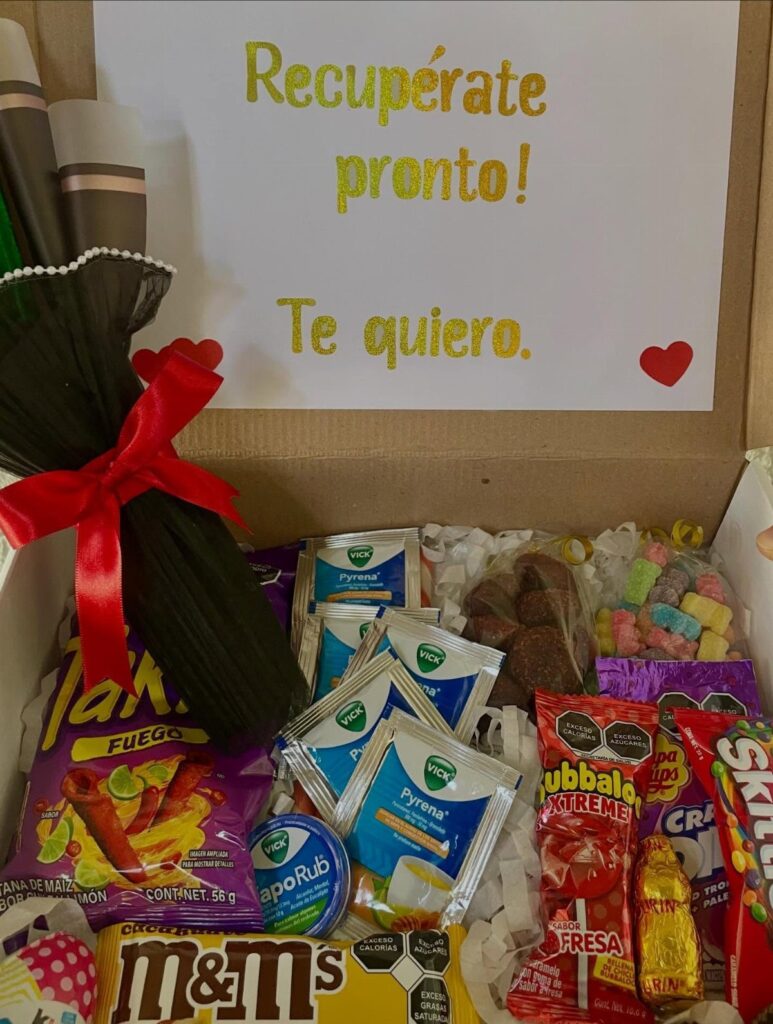 Gift box with snacks, health products, and a Spanish get well card.