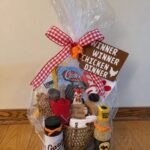 Gift basket wrapped in cellophane with a chicken dinner themed raffle sign.