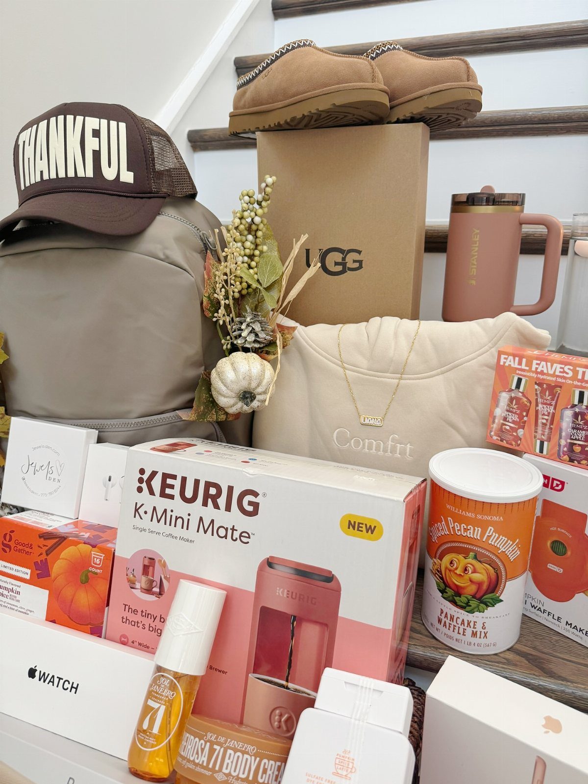 Assorted gift items including a coffee maker, boots, and accessories arranged as a basket.