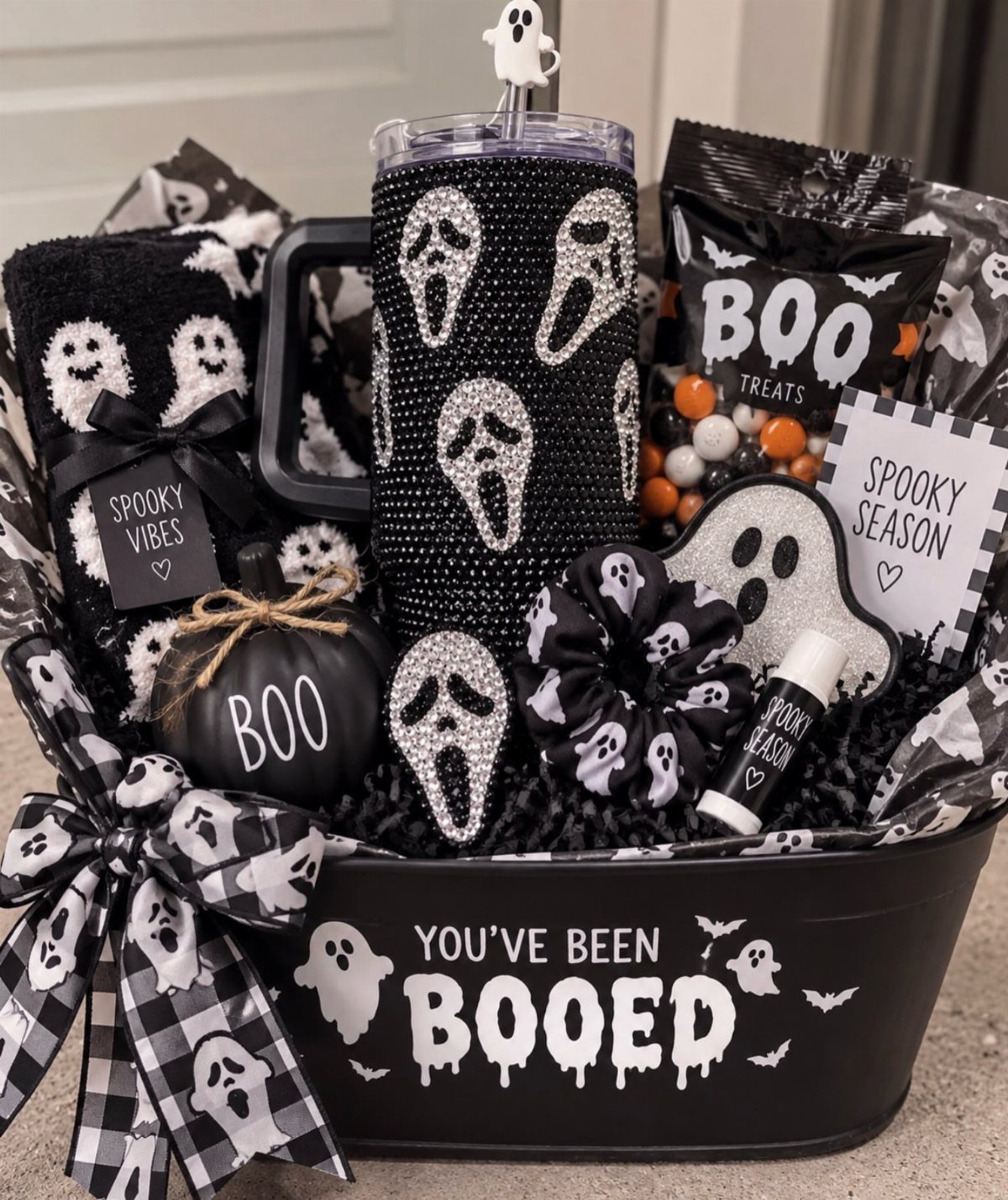 Halloween boo basket in a black tub with Scream masks and ghost accessories