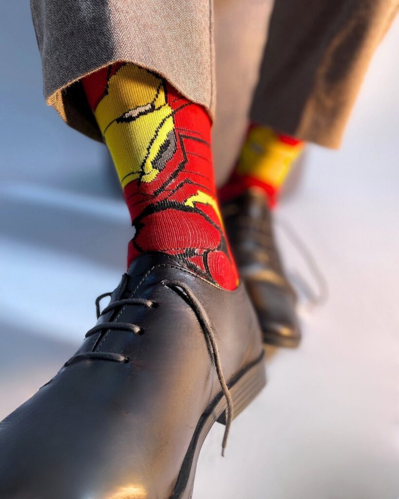 Iron Man themed red and yellow socks worn with black dress shoes.