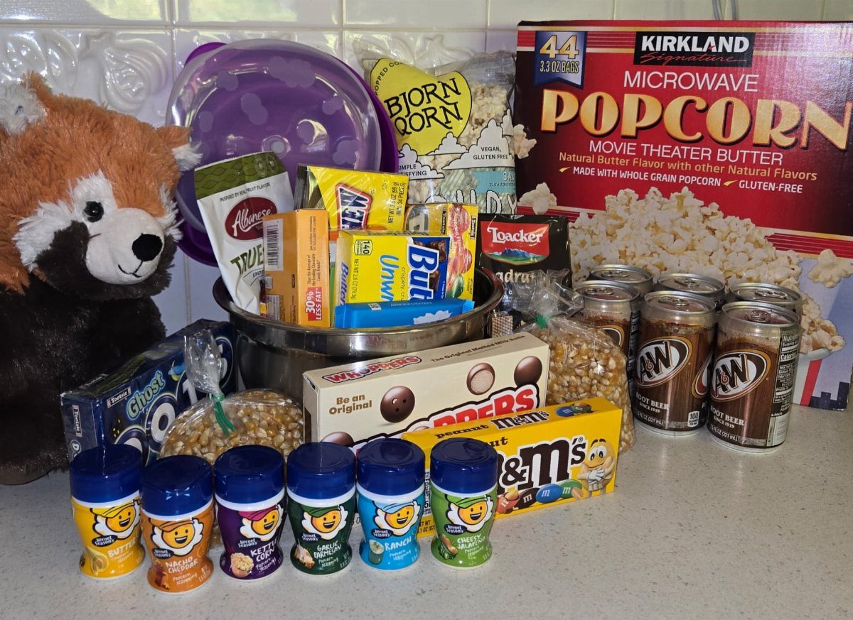 Movie snack assortment with popcorn, candies, and root beer arranged on a counter.