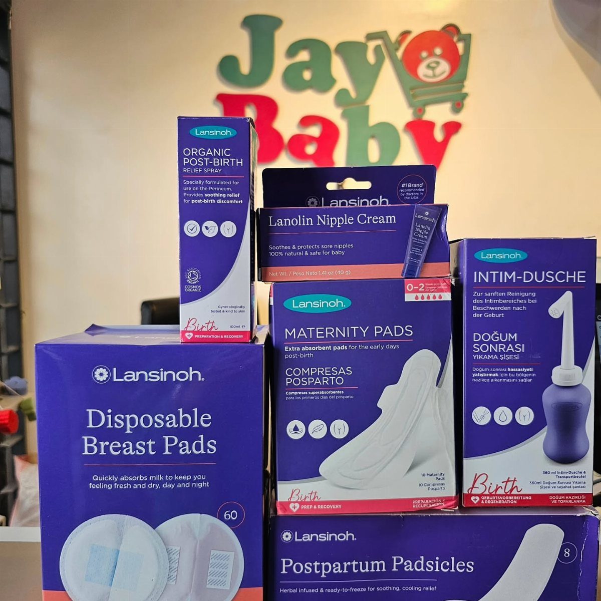 Lansinoh postpartum care products including maternity pads and a peri bottle on display.