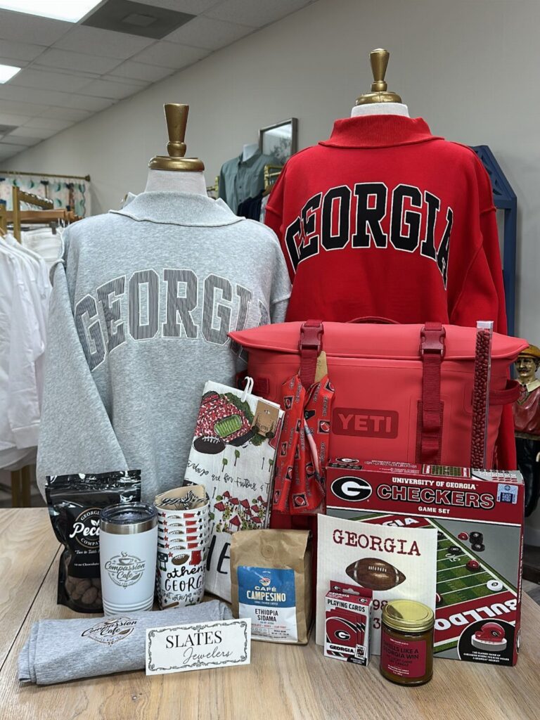 University of Georgia themed gift basket with sweatshirts, Yeti cooler, and game accessories.