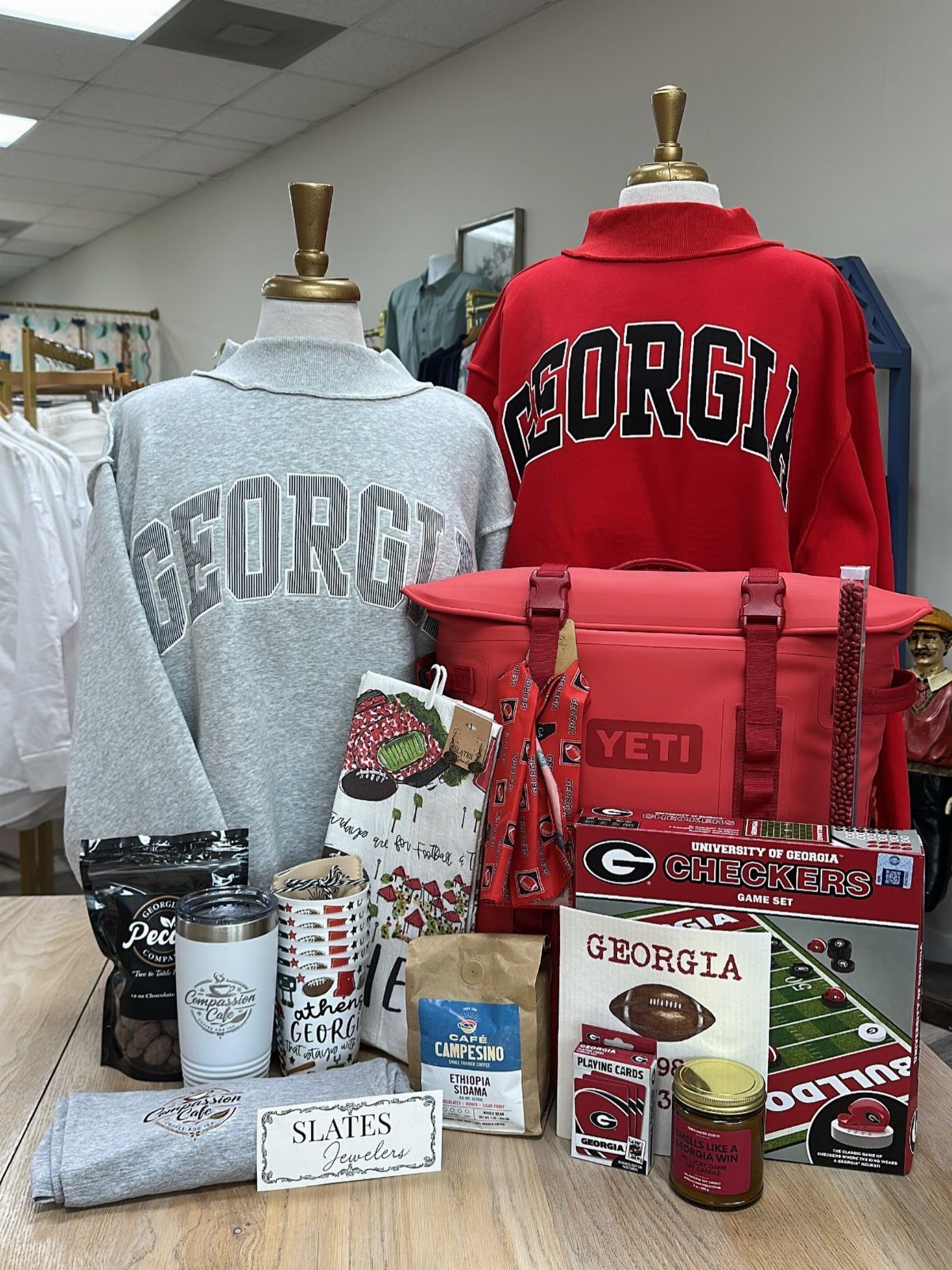 University of Georgia themed gift basket with sweatshirts, Yeti cooler, and game accessories.