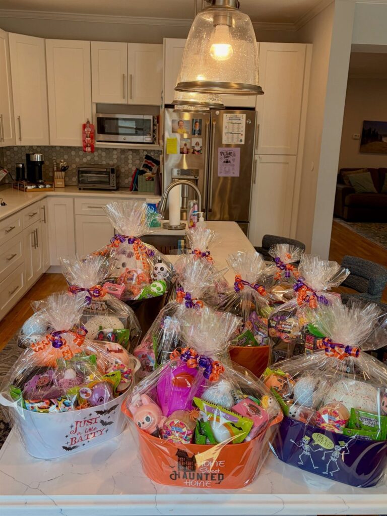 Halloween themed gift baskets wrapped in cellophane on a white kitchen counter