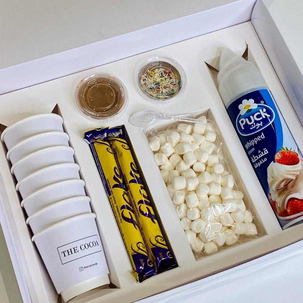 Hot chocolate gift set with cups, marshmallows, chocolate bars, and whipped cream in box